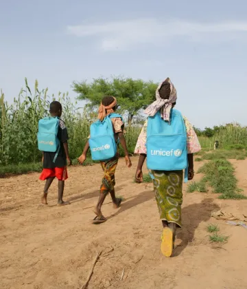 18 septembre 2010, children walk to school carrying UNICEF school bags on their backs in the village of Garin Badjini, some 18 Kms from the town of Maradi, Maradi region, south east of Niger. In Niger, children's education is a national challenge, for one child in three does not go to school. For girls, the situation is an even bigger concern: only one in two girls goes to primary school, one in ten to secondary school and one in fifty to high school.