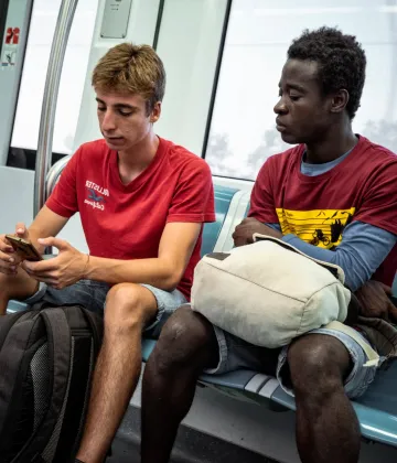 Ibrahim Kondeh takes the train with his foster brother Andrea on August 27, 2019.  Ibrahim was born Eastern Sierra Leone to a family who did subsistence farming. At 6 years old, Ibrahim moved to Freetown to attend school, where he lived with his aunt. In 2014, his father passed away and in 2016, after visiting his mother at home and experiencing what he described as a difficult and unsafe situation in his community, he decided that he needed to leave Sierra Leone.