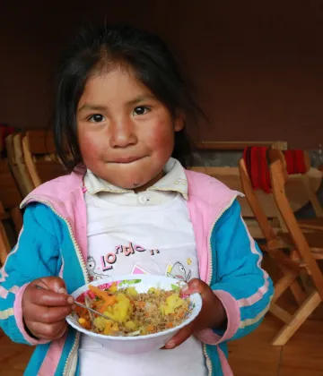 In 2019, a girl eats lunch in the Hanaq Chuquibamba community in Peru.