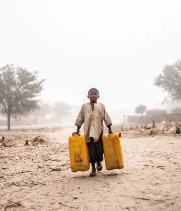 A boy fetch water for his family and the Nigerian refugee family they are hosting at their home in Maradi, Niger.