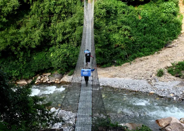 Porters and a local health official carry UNICEF-provided vaccines on difficult terrains on the way to a measles, rubella and polio vaccination campaign to be conducted at Barpak Village Development Committee (VDC) health post in Gorkha District, the epicentre of the April 25 earthquake.