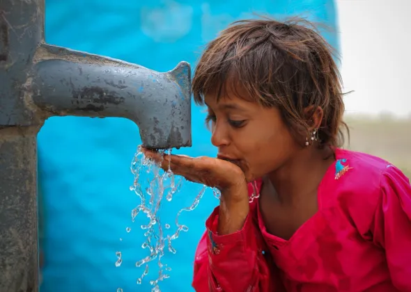 PAKISTAN: A young girls drinking water from a newly installed UNICEF supported hand pump in a village Landhi Ali Murad Shah of Jacoabad District of Sindh Province in Pakistan. 