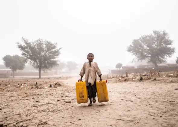 A boy fetch water for his family and the Nigerian refugee family they are hosting at their home in Maradi, Niger.