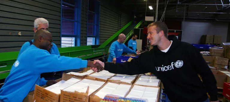 UNICEF Goodwill Ambassador David Beckham greets workers who are assembling 'school-in-a-box' kits for children affected by the tsunami disaster, at UNICEF's central supply warehouse in Copenhagen, the capital.