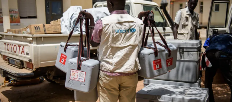 UNICEF health worker Chris Otti carries cool-boxes containing vaccines to a pick-up truck outside the hospital, ahead of a rural vaccination drive in Koch county, in Bentiu, South Sudan, Friday 5 May 2017. It is vital that vaccines be stored at the appropriate temperature from the time they are manufactured up until the moment of use. High temperatures or a drop in temperature below zero for freeze sensitive vaccines can cause vaccines to lose their potency – that is, their ability to provide protection aga