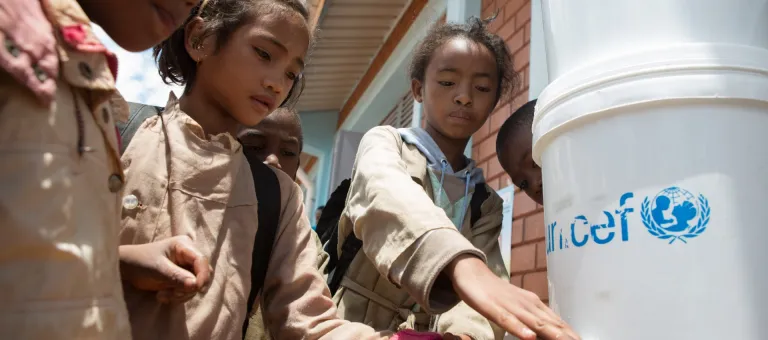 On 26 February, students get safe water from a UNICEF-provided covered bucket with a faucet, at a primary School in Ampangabe Village in Analamanga Region.