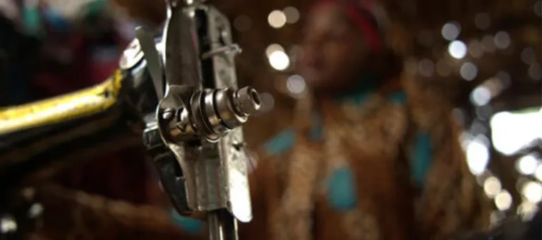 Khady tijdens een opleiding voor kleermaker in Nigeria