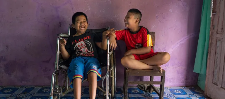 Syaiful (links), 12 jaar, heeft een lichamelijke beperking. Hij zit naast zijn beste vriend Kevin, die een visuele beperking heeft. 