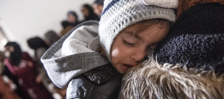Ishak, 1,5 jaar, slaapt op de schouder van zijn mama, Abir. in Jarba, Oost-Ghouta, Syrië, op 6 maart 2022. © UNICEF/UN0634995/Hasan Belal