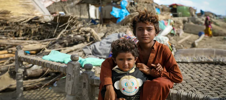 Kamlash, 9 jaar en zijn driejarige broertje Anish vonden een tijdelijk onderkomen naast een verlaten spoorlijn vlakbij het water in Sindh, Pakistan. © UNICEF/UN0698981/Zaidi