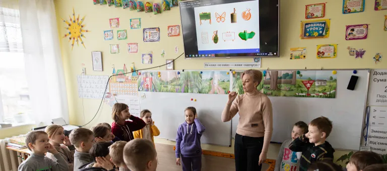 Oekraïense schoolkinderen luisteren aandachtig naar de leerkracht die hen vertelt over het gevaar van mijnen. 
