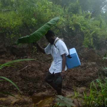 General Nurse Dominic, from Melsisi Mini Hospital, trekking accross the mountainous Pentecost Island to deliver the vaccine order to the remote Tsingbwege Dispensary.